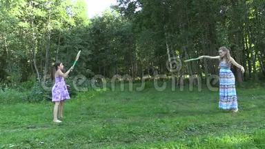 有活力的孕妇和女孩在公园打羽毛球